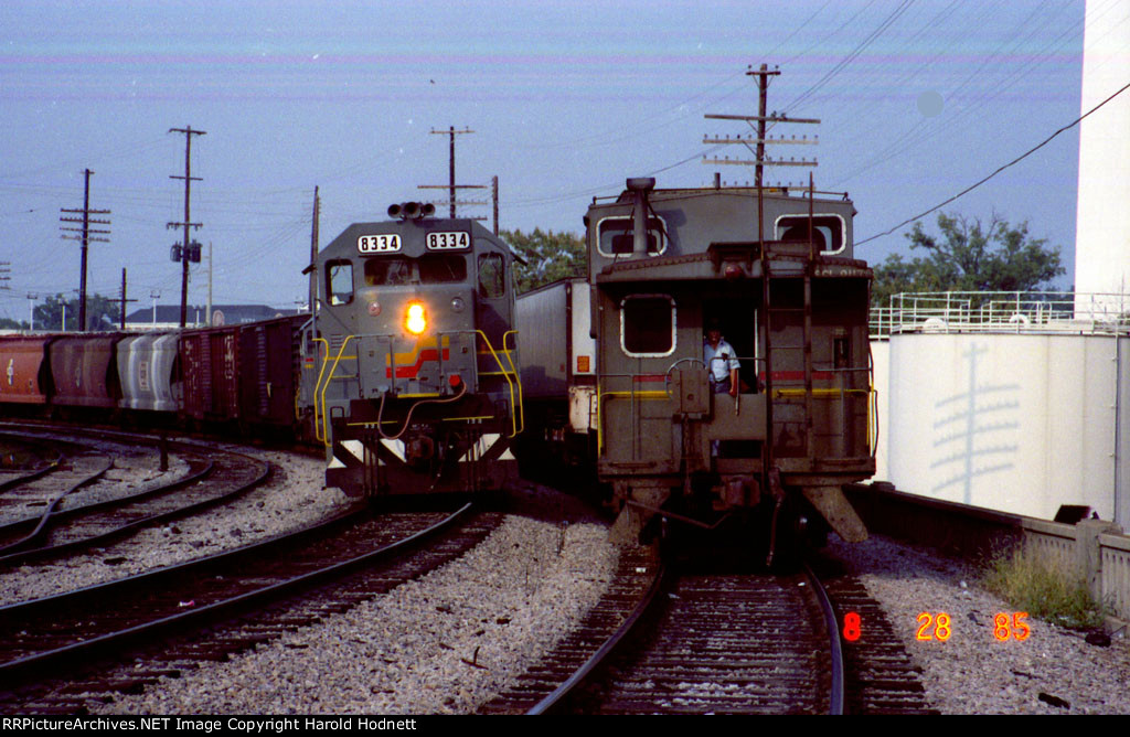 SBD 8334 leads a southbound train past thd caboose on a northbound piggyback train